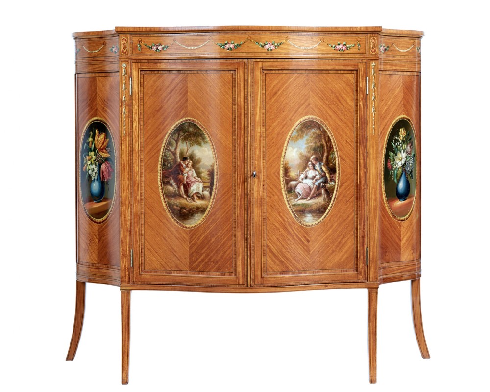 A late 19th-century Sheraton Revival satinwood cabinet featuring hand-painted floral swags, classical figurative oval panels, intricate wood marquetry, and tapered legs.