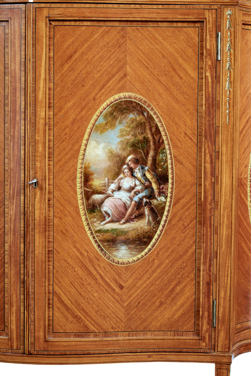 A late 19th-century Sheraton Revival satinwood cabinet featuring hand-painted floral swags, classical figurative oval panels, intricate wood marquetry, and tapered legs. View VIII