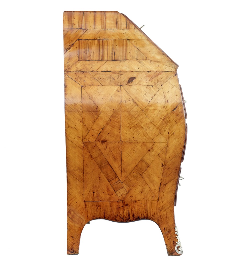 An 18th-century Rococo bureau crafted from yew and elm wood featuring a curved bombe body, slant-front writing slope, three drawers, and decorative cast brass handles. View VII
