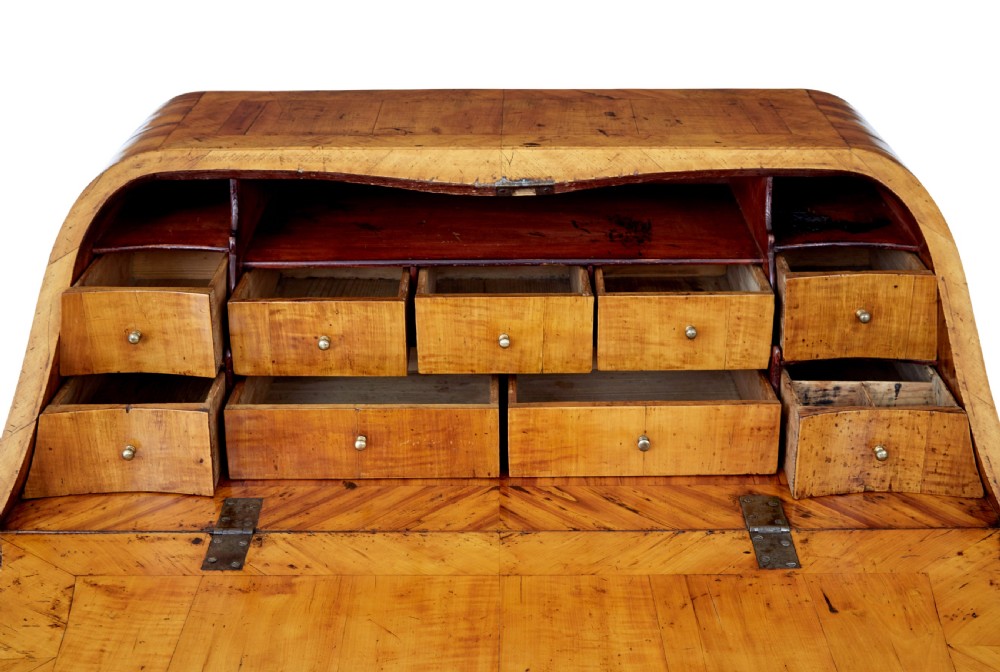 An 18th-century Rococo bureau crafted from yew and elm wood featuring a curved bombe body, slant-front writing slope, three drawers, and decorative cast brass handles. View XII