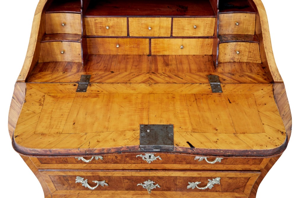An 18th-century Rococo bureau crafted from yew and elm wood featuring a curved bombe body, slant-front writing slope, three drawers, and decorative cast brass handles. View XIII