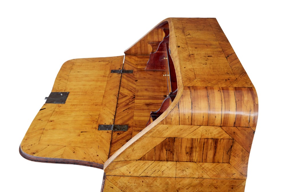 An 18th-century Rococo bureau crafted from yew and elm wood featuring a curved bombe body, slant-front writing slope, three drawers, and decorative cast brass handles. View XIV