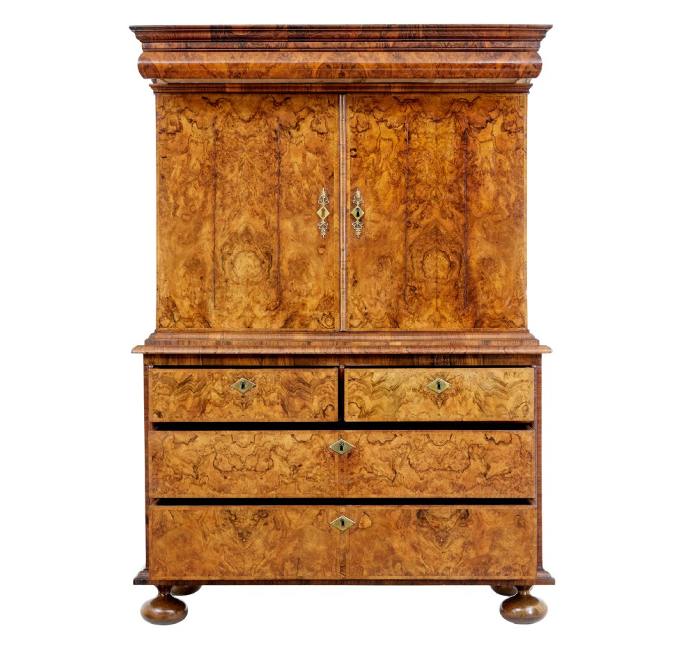 An 18th-century George I burr walnut cabinet on chest featuring double upper doors, brass keyhole escutcheons, and turned bun feet. View V