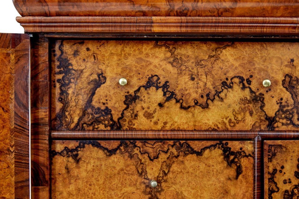 An 18th-century George I burr walnut cabinet on chest featuring double upper doors, brass keyhole escutcheons, and turned bun feet. View IX