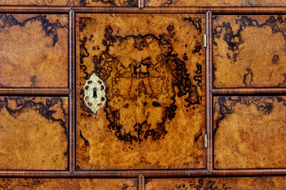 An 18th-century George I burr walnut cabinet on chest featuring double upper doors, brass keyhole escutcheons, and turned bun feet. View X
