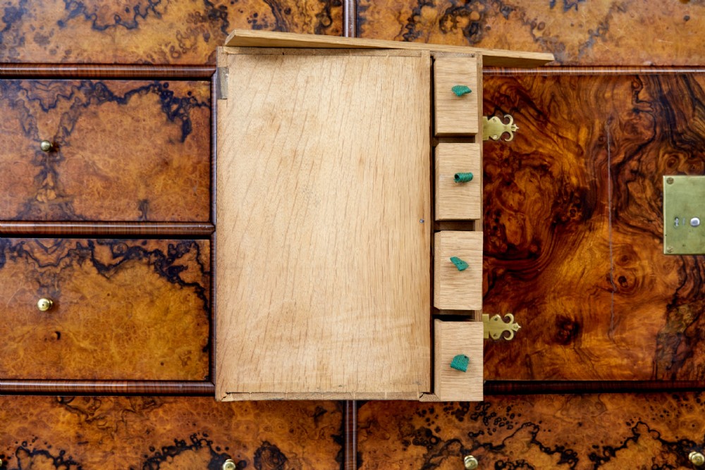 An 18th-century George I burr walnut cabinet on chest featuring double upper doors, brass keyhole escutcheons, and turned bun feet. View XII
