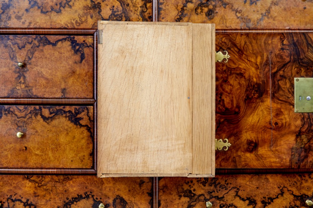 An 18th-century George I burr walnut cabinet on chest featuring double upper doors, brass keyhole escutcheons, and turned bun feet. View XIII