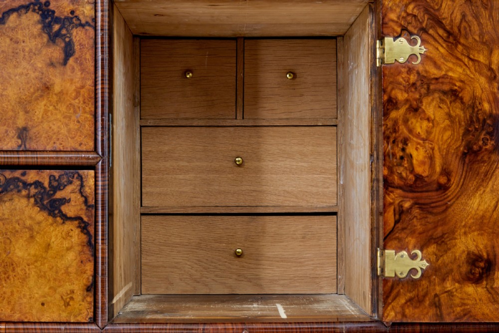 An 18th-century George I burr walnut cabinet on chest featuring double upper doors, brass keyhole escutcheons, and turned bun feet. View XIV