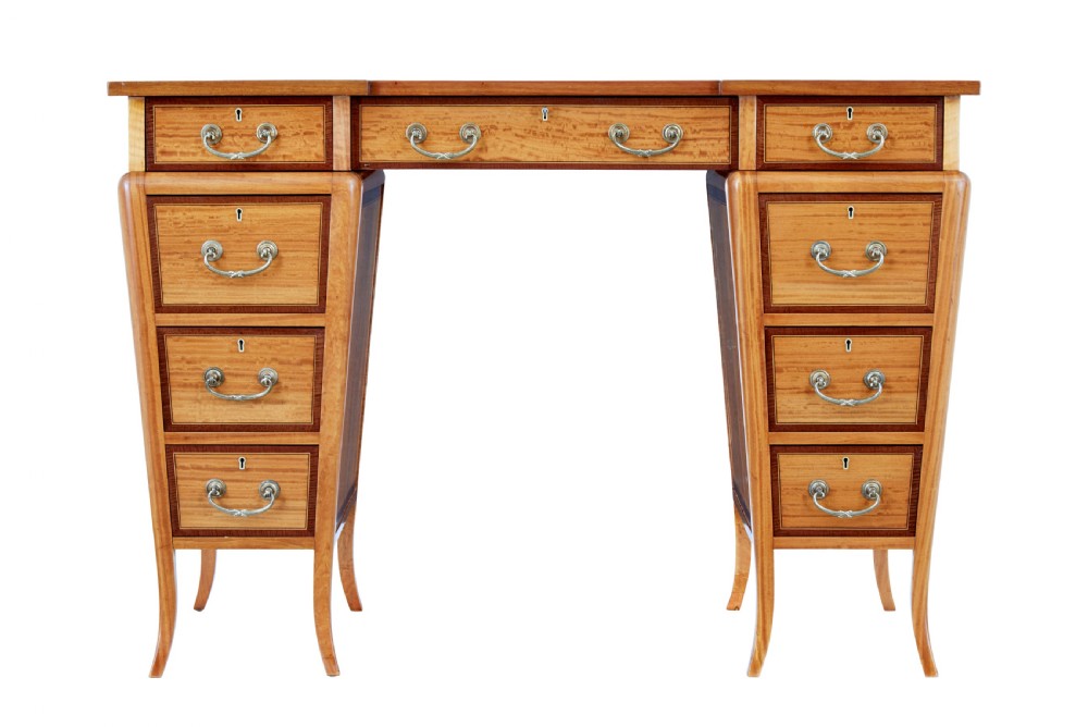 An early 20th-century Sheraton Revival satinwood pedestal desk featuring inlaid mahogany crossbanding, seven drawers with brass handles, and gently splayed legs. View III