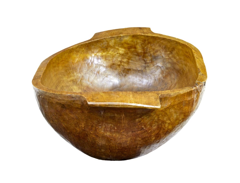 A large hand-carved wooden dough bowl with integrated end handles and a polished warm brown finish displaying visible adze marks. View II