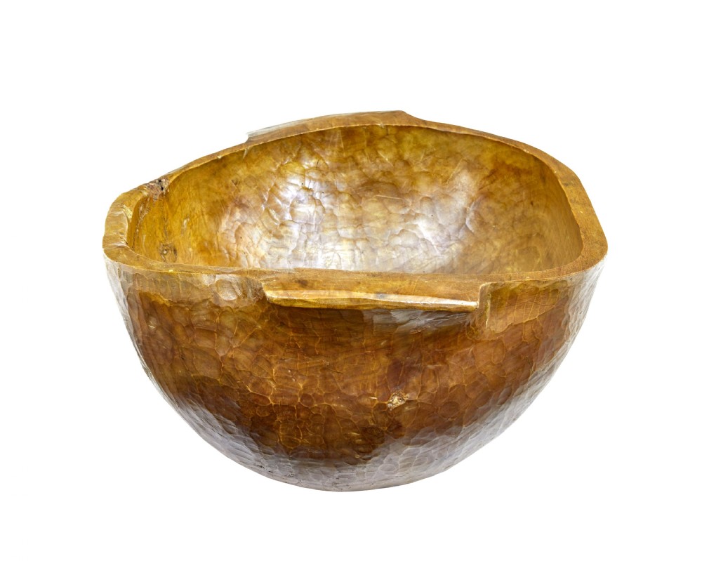 A large hand-carved wooden dough bowl with integrated end handles and a polished warm brown finish displaying visible adze marks. View IV