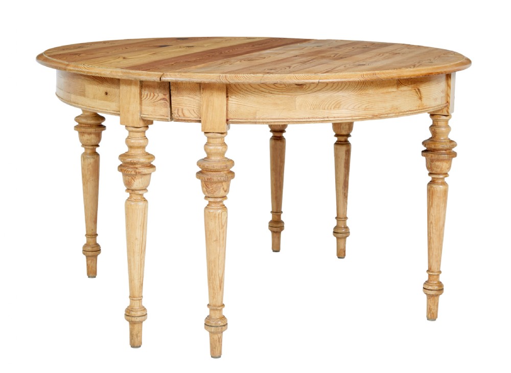 A pair of 19th-century Swedish pine demi-lune tables with turned legs placed together to form a circular top.