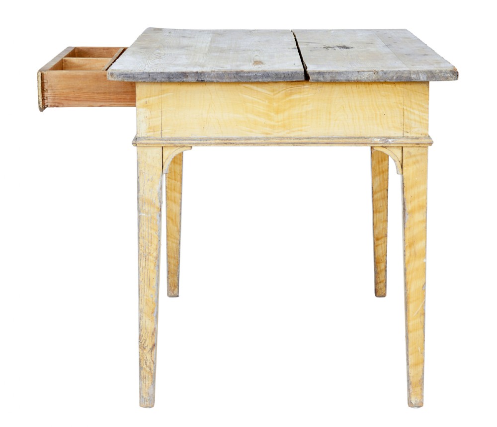 A 19th-century Swedish pine kitchen table featuring a yellow painted frame, square tapered legs, a single frieze drawer, and a scrubbed wooden tabletop. View VI