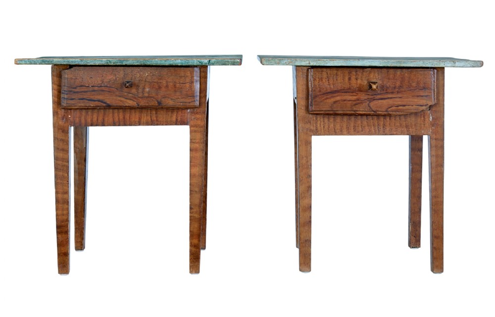 A pair of small wooden Swedish side tables featuring single drawers with square wooden knobs, straight tapered legs, and painted green tops.
