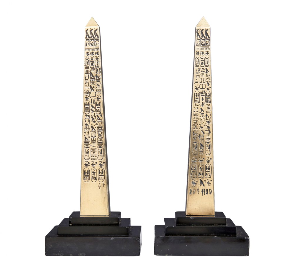 A pair of brass obelisks with incised hieroglyphic carvings mounted on stepped black marble bases. View II