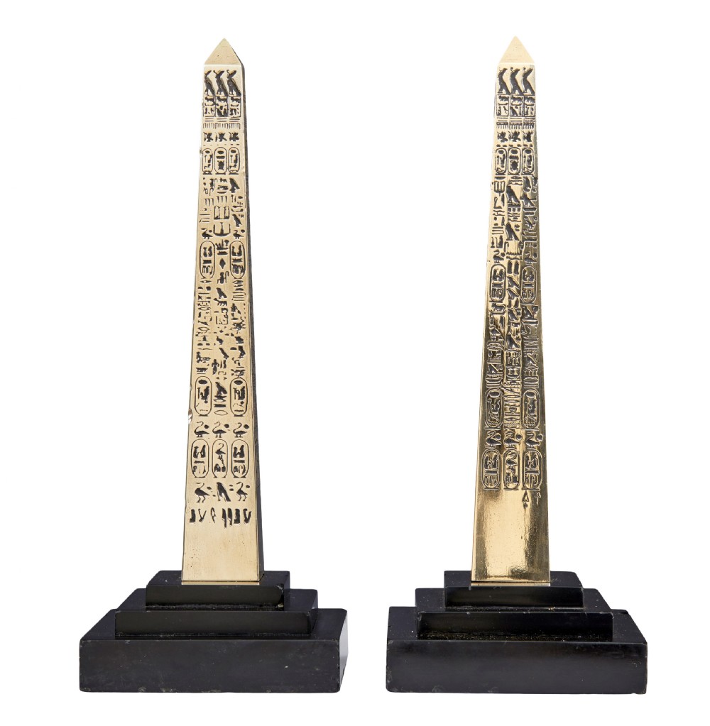 A pair of brass obelisks with incised hieroglyphic carvings mounted on stepped black marble bases. View III