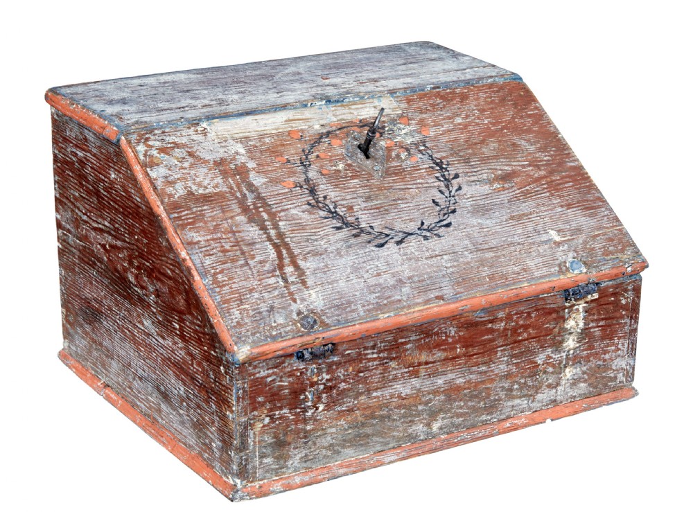A mid 19th-century Swedish wooden tabletop writing desk with a slanted lid, distressed red and grey paint finish, and a hand-painted foliage wreath motif around the keyhole.