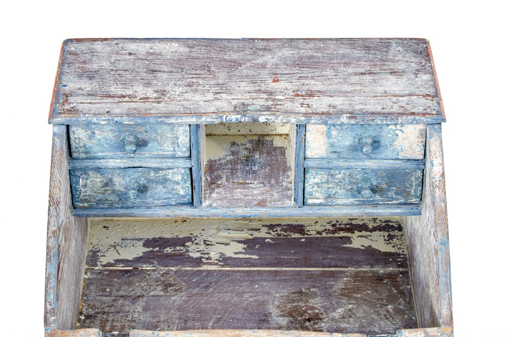 A mid 19th-century Swedish wooden tabletop writing desk with a slanted lid, distressed red and grey paint finish, and a hand-painted foliage wreath motif around the keyhole. View II