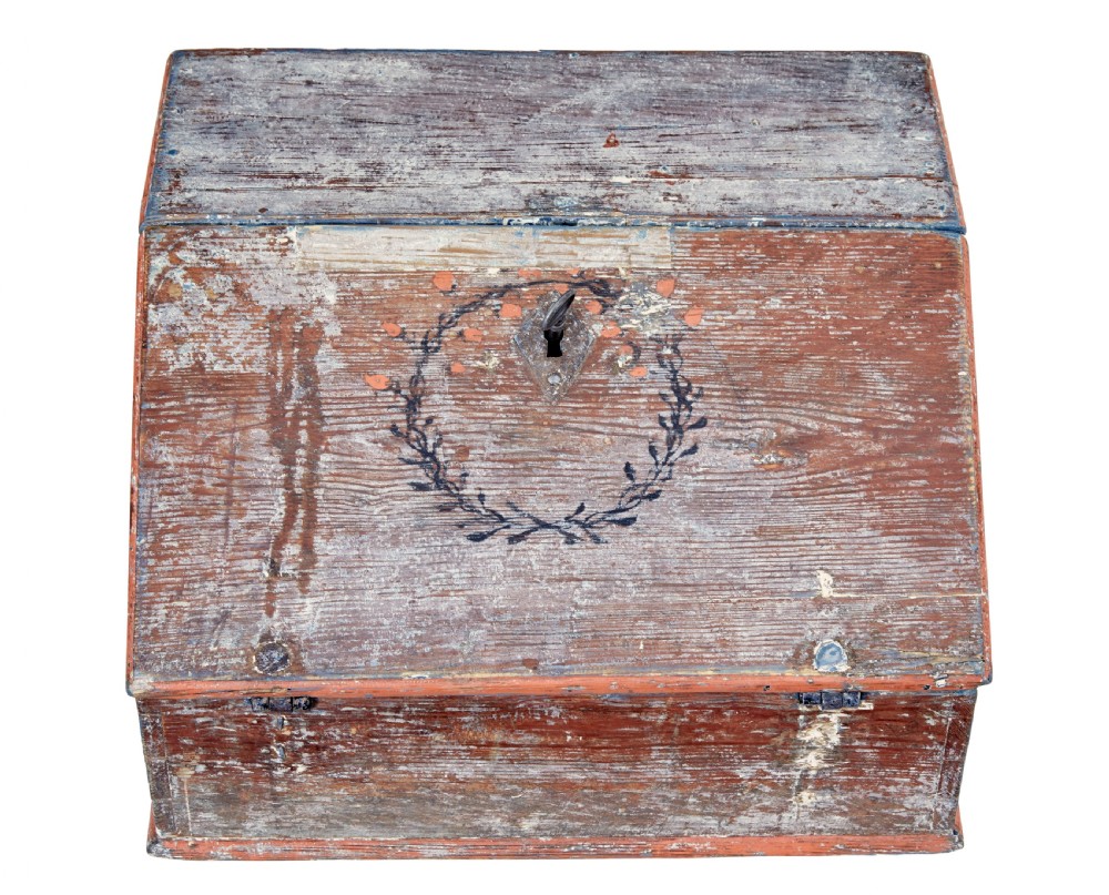 A mid 19th-century Swedish wooden tabletop writing desk with a slanted lid, distressed red and grey paint finish, and a hand-painted foliage wreath motif around the keyhole. View IV