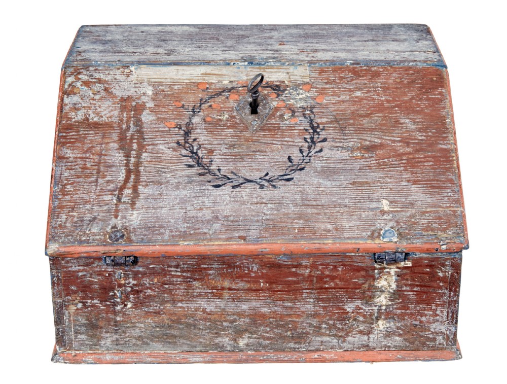 A mid 19th-century Swedish wooden tabletop writing desk with a slanted lid, distressed red and grey paint finish, and a hand-painted foliage wreath motif around the keyhole. View VI