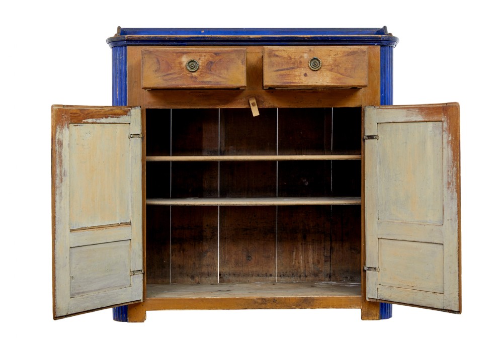 A 19th-century Swedish pine kitchen cupboard with ochre faux-grained body, vibrant blue fluted columns, two top drawers, and blue panelled double doors. View III