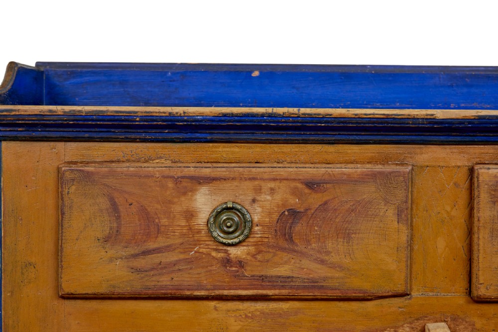 A 19th-century Swedish pine kitchen cupboard with ochre faux-grained body, vibrant blue fluted columns, two top drawers, and blue panelled double doors. View VII