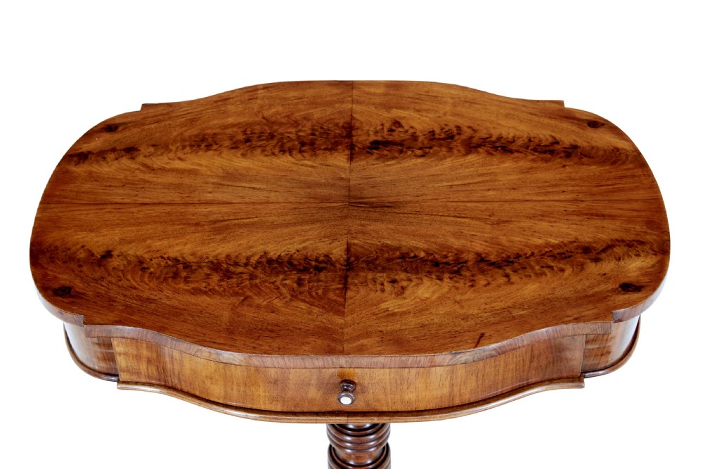 A 19th-century flame mahogany side table with a shaped top, turned central column stem, and detailed carved scroll feet. View V