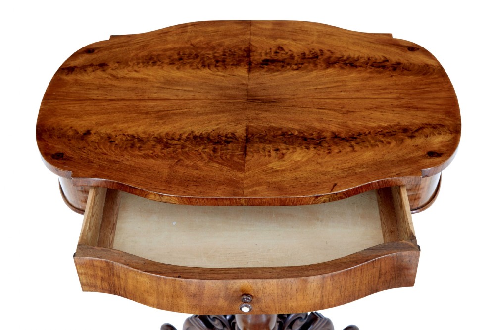 A 19th-century flame mahogany side table with a shaped top, turned central column stem, and detailed carved scroll feet. View VI