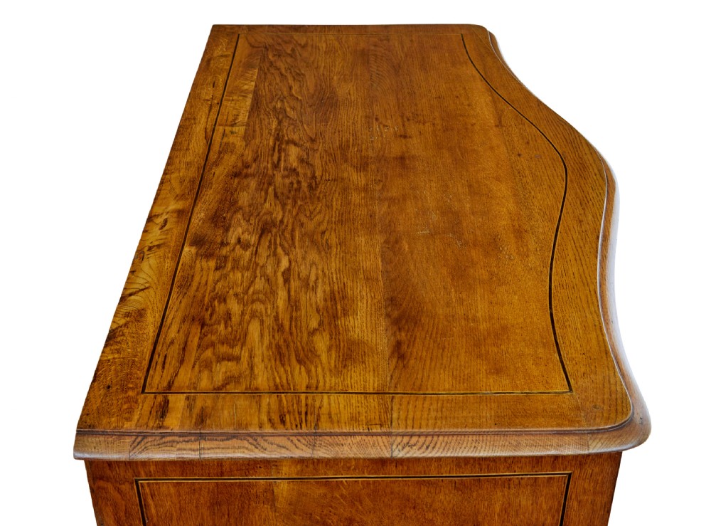An early nineteenth-century Swedish oak chest of drawers featuring detailed botanical wood inlay, a carved apron, and decorative brass hardware. View XI