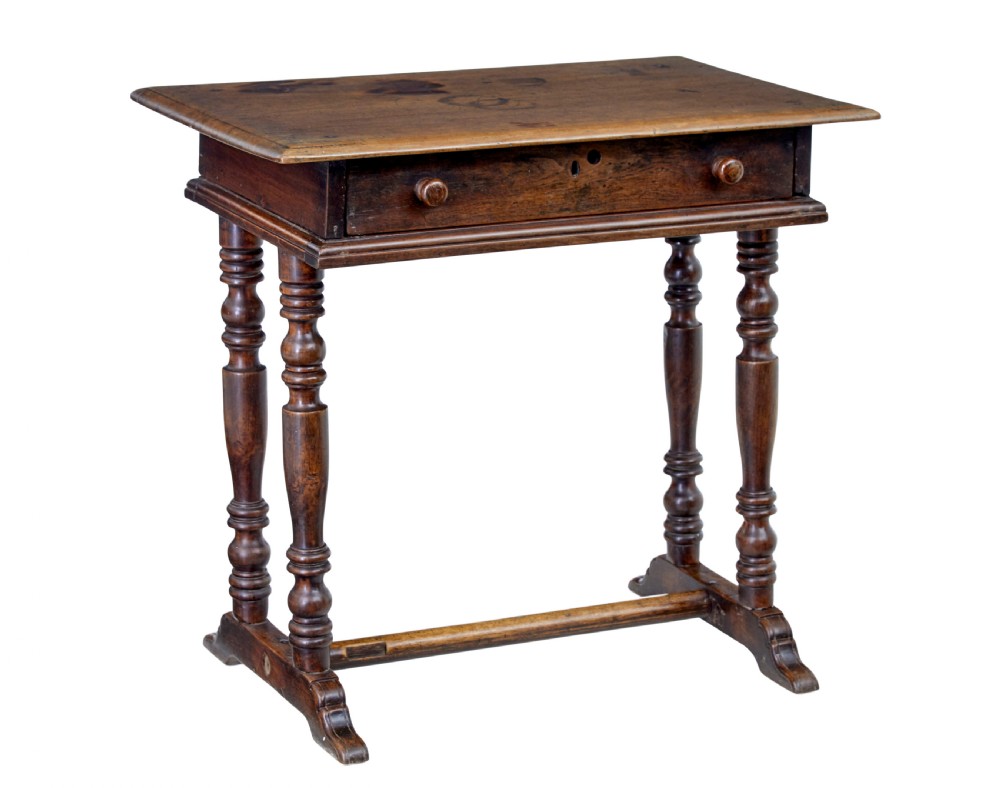 An 18th-century rustic walnut side table featuring turned legs, a single drawer with wooden knobs, and a low stretcher base.