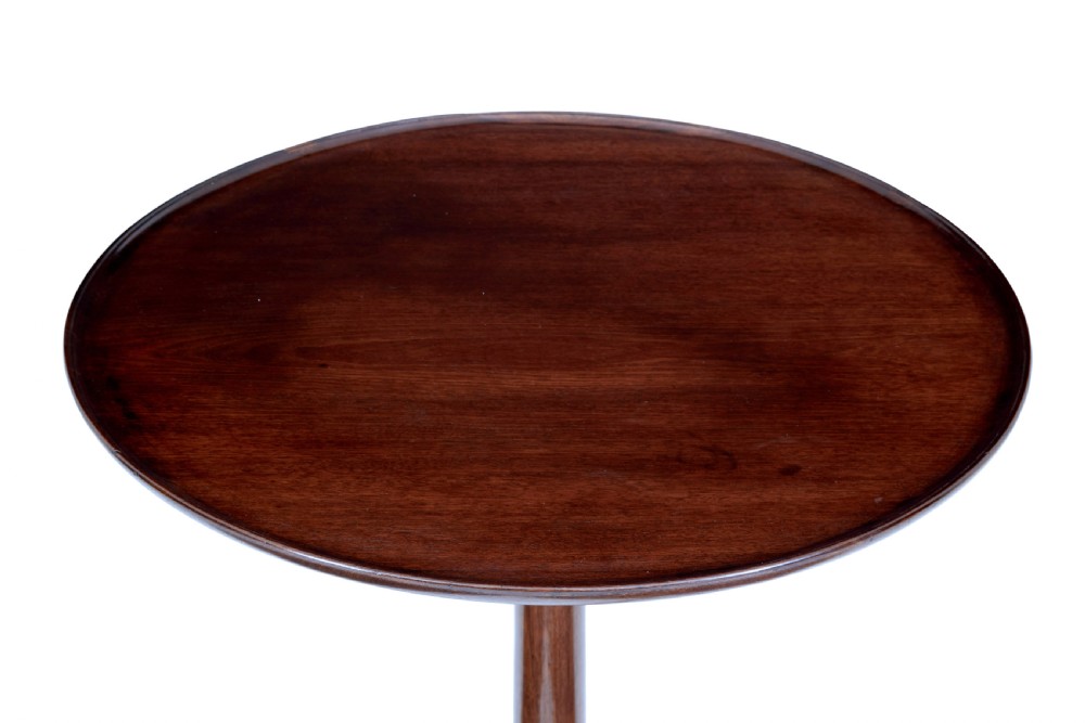 An early 19th-century Georgian mahogany tripod table with a circular tilt top, turned central column, and three cabriole legs on pad feet. View V