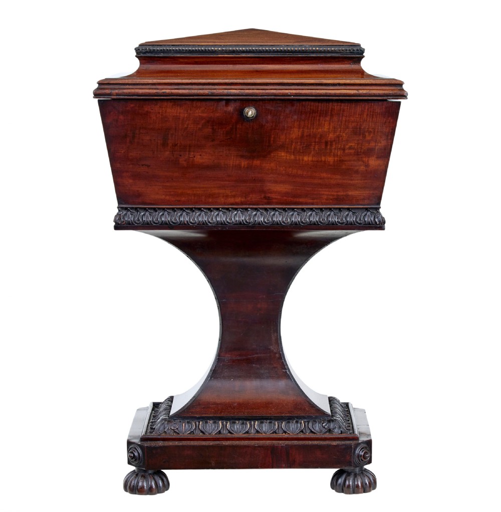 A 19th-century carved mahogany teapoy featuring a stepped hinged lid, flared central pedestal base, and carved feet. View II