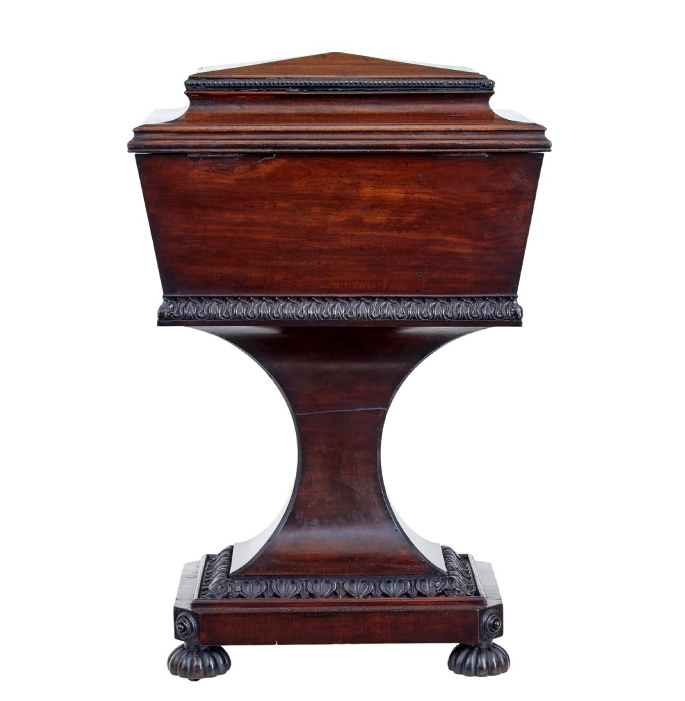 A 19th-century carved mahogany teapoy featuring a stepped hinged lid, flared central pedestal base, and carved feet. View IV
