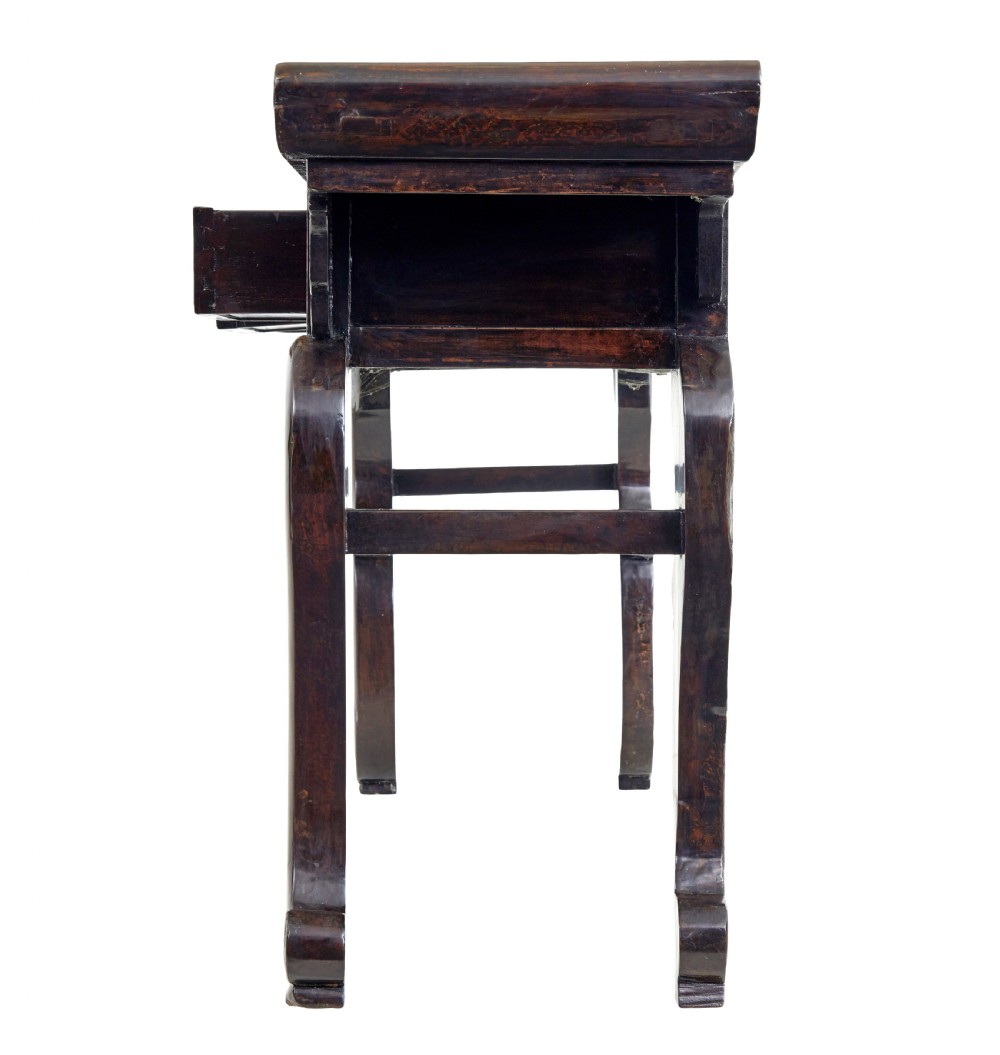 A nineteenth-century dark lacquered Chinese hardwood altar table with three drawers, everted end flanges, carved aprons, and curved legs. View IV
