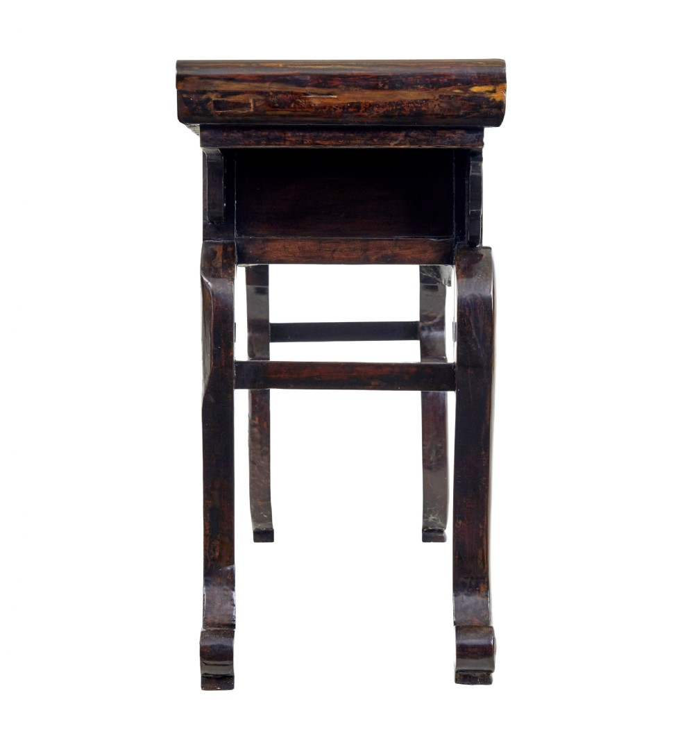 A nineteenth-century dark lacquered Chinese hardwood altar table with three drawers, everted end flanges, carved aprons, and curved legs. View VI