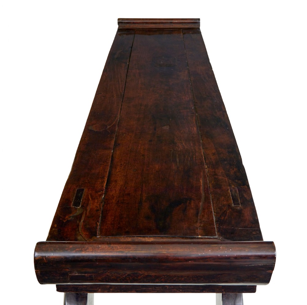 A nineteenth-century dark lacquered Chinese hardwood altar table with three drawers, everted end flanges, carved aprons, and curved legs. View VII
