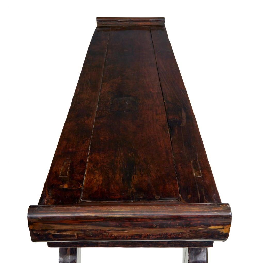 A nineteenth-century dark lacquered Chinese hardwood altar table with three drawers, everted end flanges, carved aprons, and curved legs. View VIII