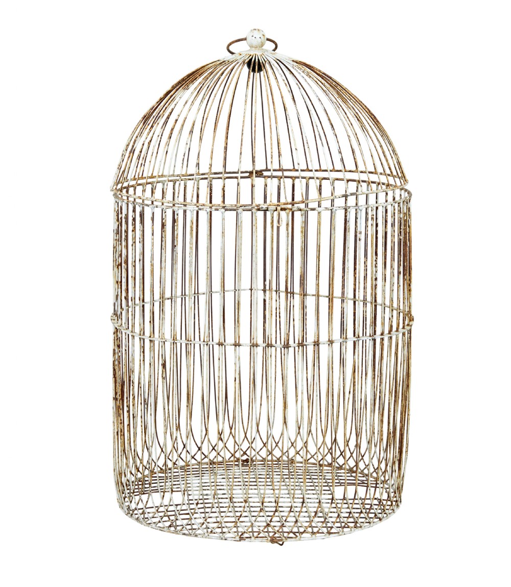 A large 19th-century domed wire bird cage with a distressed painted white finish showing areas of natural oxidisation and a top hanging loop.