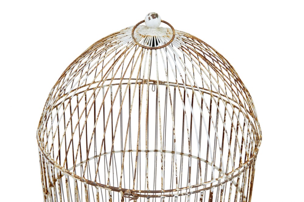 A large 19th-century domed wire bird cage with a distressed painted white finish showing areas of natural oxidisation and a top hanging loop. View V