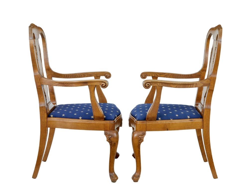 A pair of 19th-century carved oak open armchairs featuring vasiform splats, cabriole legs, carved seat aprons, and blue star-patterned upholstery. View IV