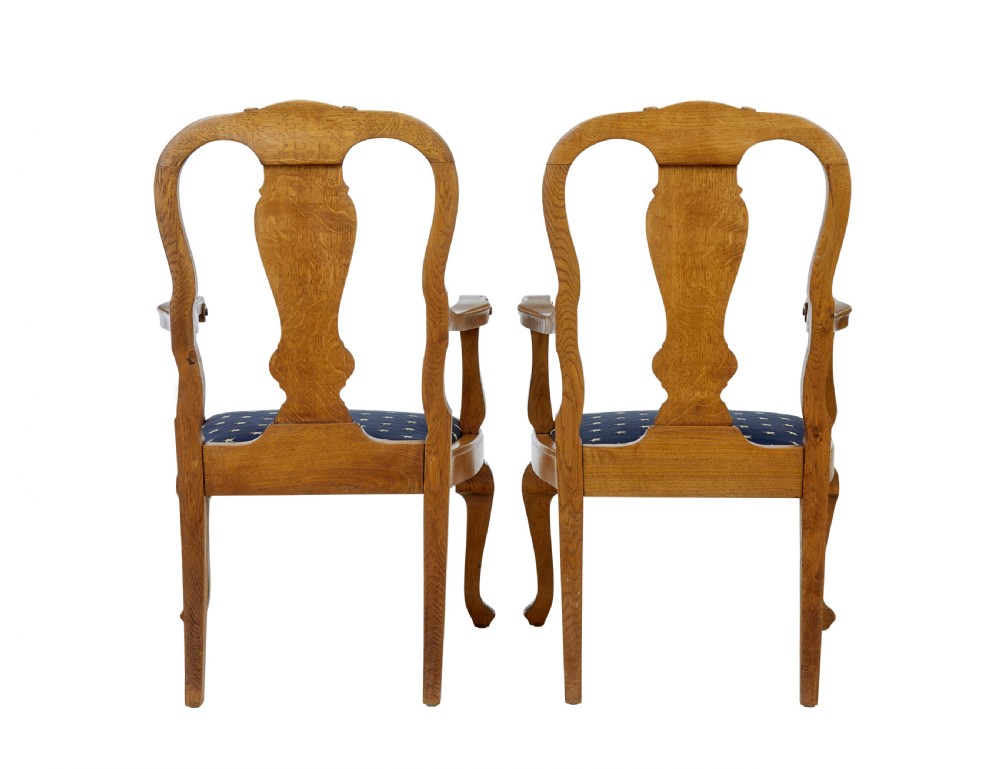 A pair of 19th-century carved oak open armchairs featuring vasiform splats, cabriole legs, carved seat aprons, and blue star-patterned upholstery. View V