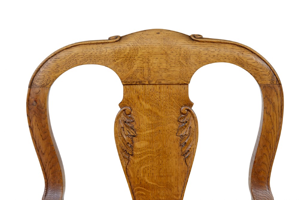 A pair of 19th-century carved oak open armchairs featuring vasiform splats, cabriole legs, carved seat aprons, and blue star-patterned upholstery. View VI