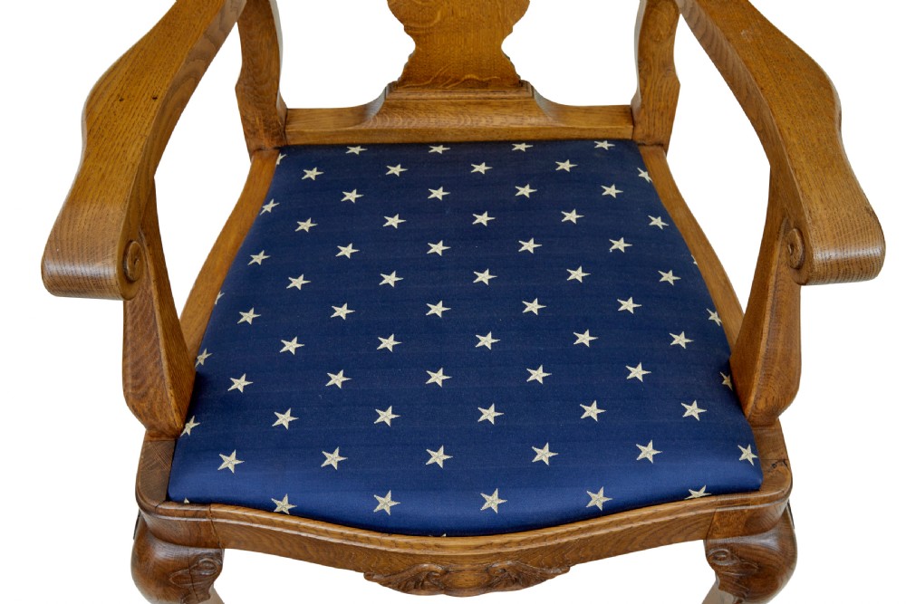 A pair of 19th-century carved oak open armchairs featuring vasiform splats, cabriole legs, carved seat aprons, and blue star-patterned upholstery. View VII