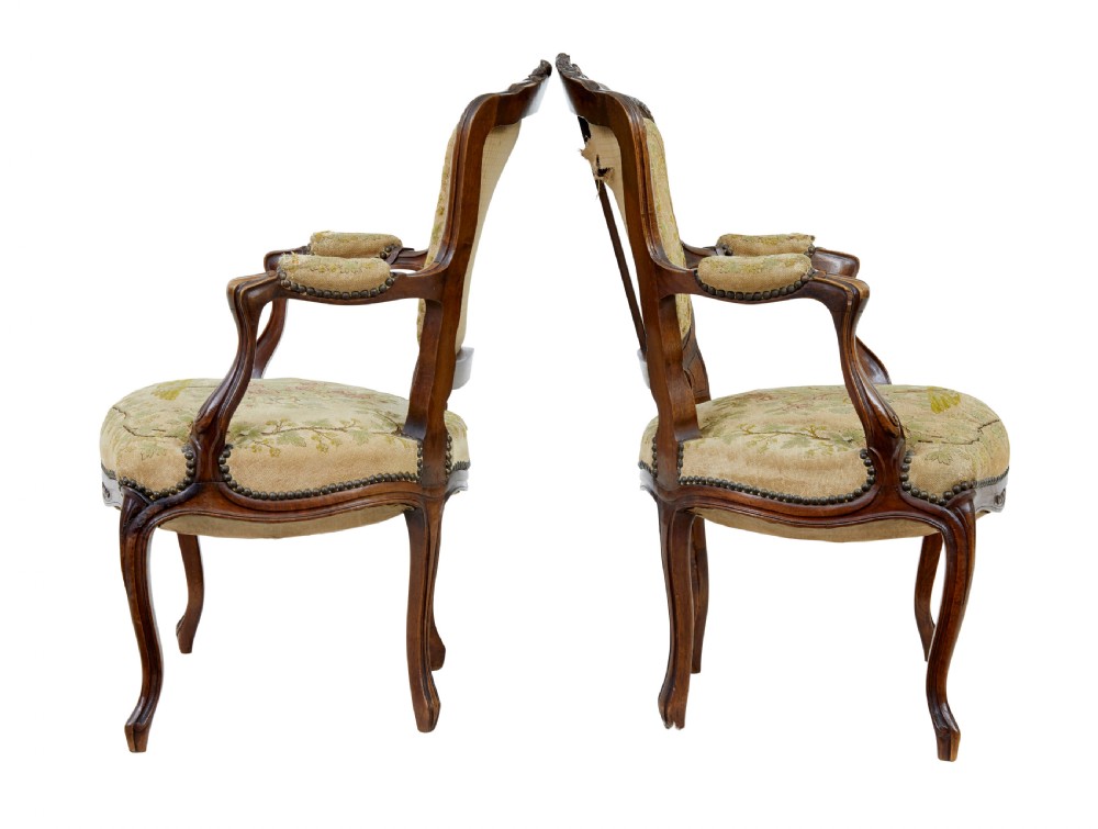 A pair of 19th-century French fauteuil armchairs with carved walnut frames and floral needlepoint upholstered seats and backs. View II