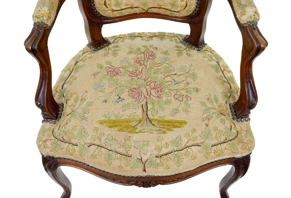 A pair of 19th-century French fauteuil armchairs with carved walnut frames and floral needlepoint upholstered seats and backs. View V