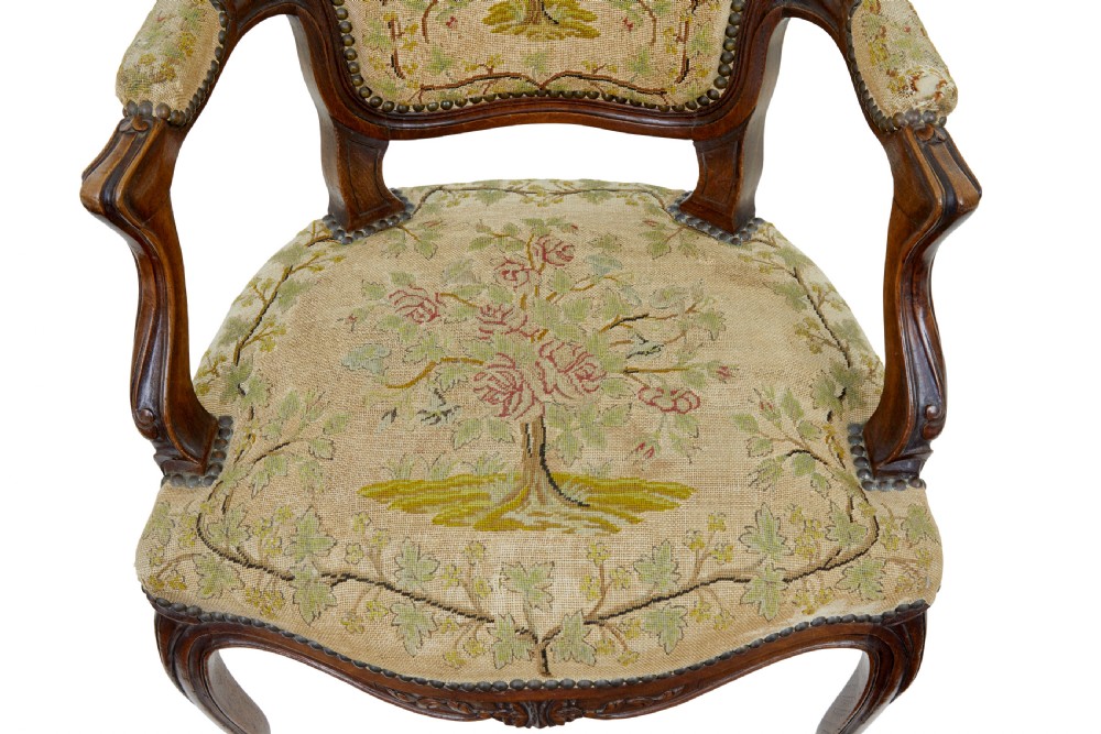A pair of 19th-century French fauteuil armchairs with carved walnut frames and floral needlepoint upholstered seats and backs. View VIII