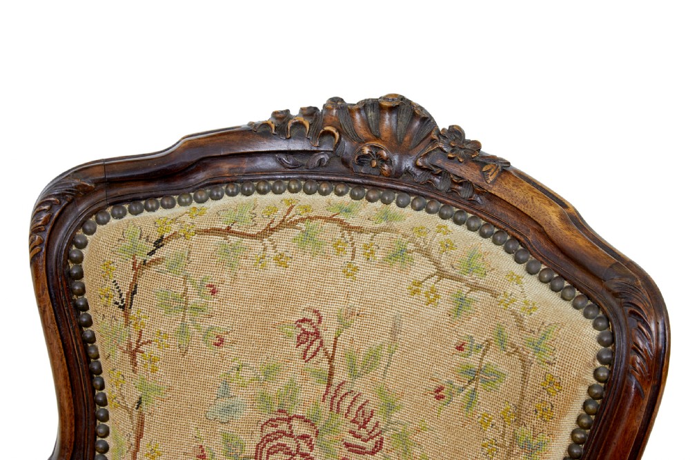 A pair of 19th-century French fauteuil armchairs with carved walnut frames and floral needlepoint upholstered seats and backs. View IX
