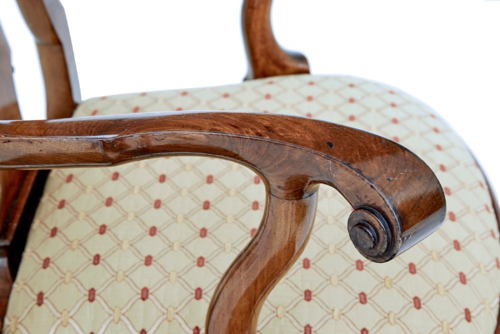 A set of carved walnut dining chairs featuring vasiform splat backs, upholstered drop-in seats, and cabriole legs ending in claw and ball feet. View VI