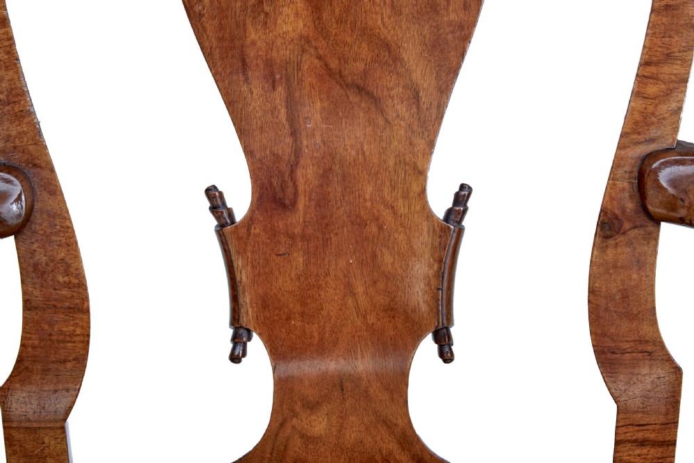 A set of carved walnut dining chairs featuring vasiform splat backs, upholstered drop-in seats, and cabriole legs ending in claw and ball feet. View VIII