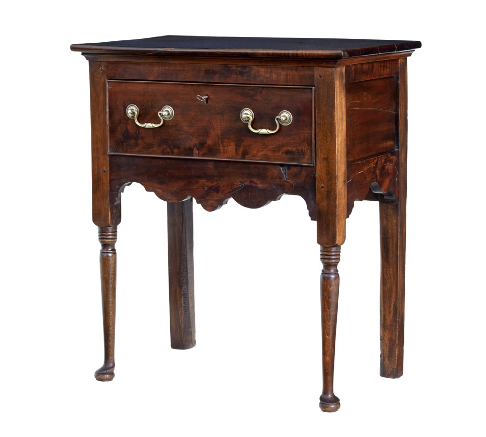 An 18th-century yew wood lowboy table featuring a single drawer with brass handles, a scalloped apron, and turned legs.